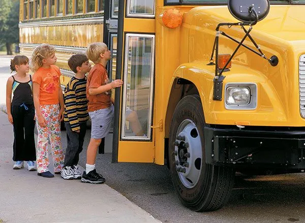 children getting on a yellow bus